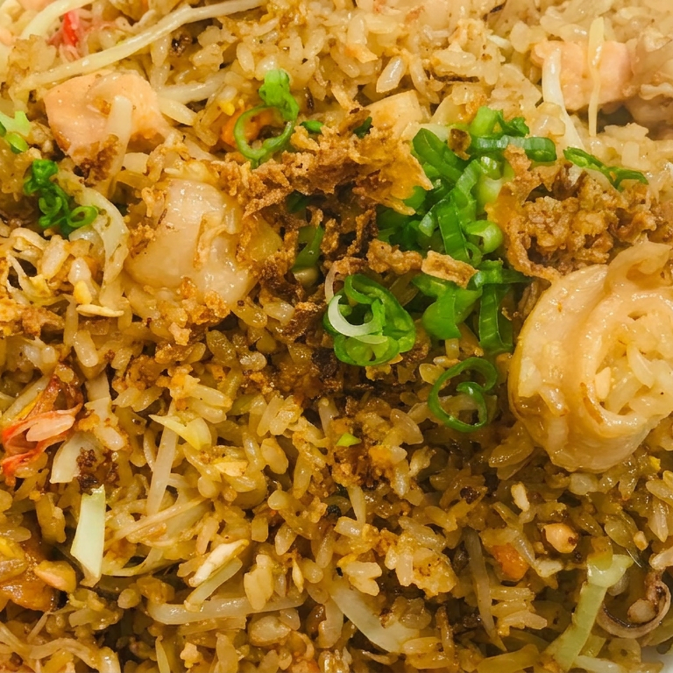 Close-up of fried rice with shrimp, chicken, bean sprouts, scallions, and crispy fried toppings.